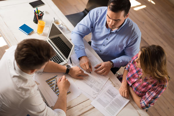 advisor with couple at table image, tax planning